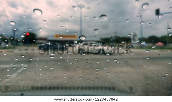 Rain drops on the car window. Blurred, Grain image.\
Selective focus. .