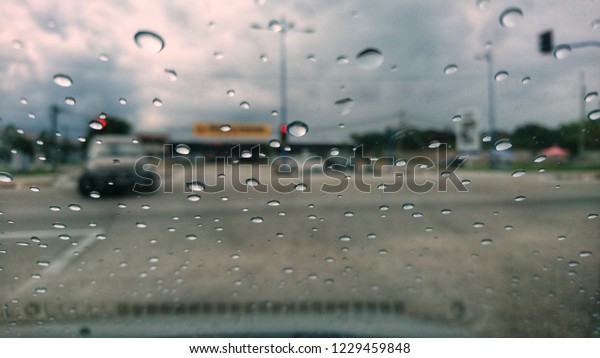 Rain drops on the car window. Blurred, Grain image.
Selective focus. .