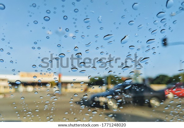 rain drops on
car window at traffic light in road. selective focus. image maybe
sightly blur, noise or
grain.