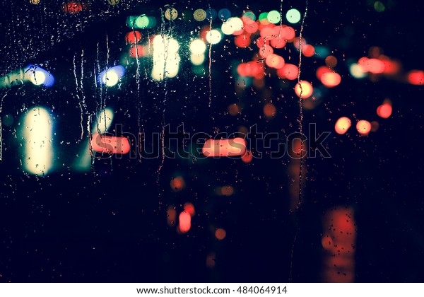 Rain drops on car
window with road light bokeh, City life in night in rainy season
abstract background,water drop on the glass, night storm raining
car driving concept.