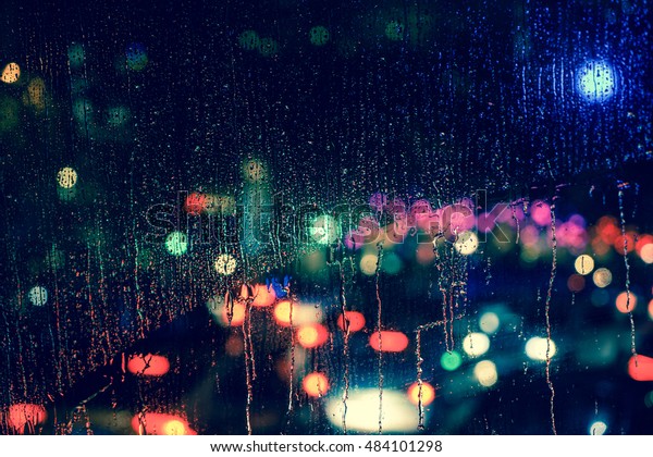Rain drops on car
window with road light bokeh, City life in night in rainy season
abstract background,water drop on the glass, night storm raining
car driving concept.