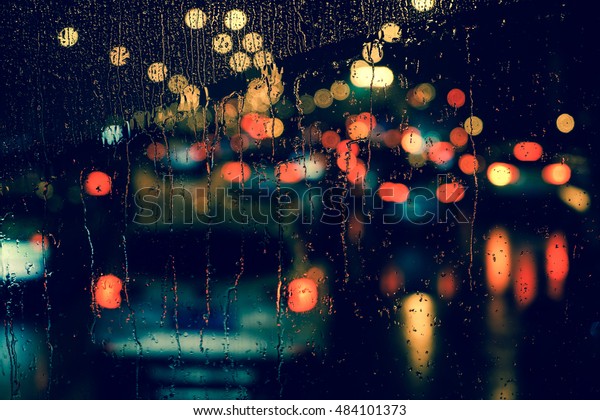 Rain drops on car\
window with road light bokeh, City life in night in rainy season\
abstract background,water drop on the glass, night storm raining\
car driving concept.