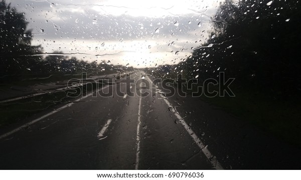 Rain\
drops on car window/Driving on the highway in\
rain.