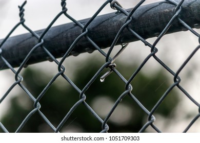 rain drops on chain link fence after a storm