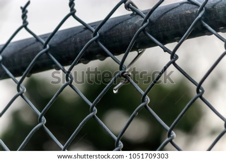 rain drops on chain link fence after a storm