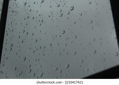 Rain Drops On Clear Glass Window On An Overcast Foggy Day. Concept For Low Mood, Depression, Out Of Sorts, Grey, Sad, Rainy Days, Stuck Indoors