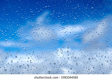 Rain drops on the glass. Beautiful blue and white sky. Sky background