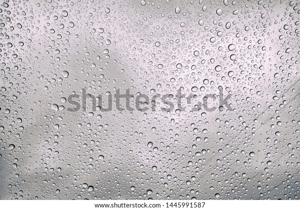 Rain drops on the glass is\
melancholy. Drops on car window. Winter raining day in\
city.