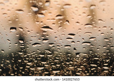 Rain Drops On Glass Widow Of A Car In The Evening Sunset.