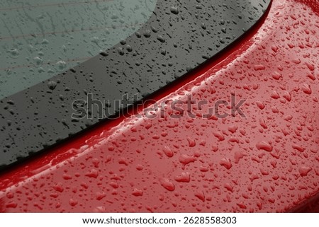 Rain drops on top of a red sports car