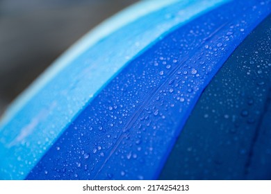 Rain Drops On Umbrella. Blue Rainy Background. Concept For Bad Weather, Forecast, Protection, Safety, Climate Changes