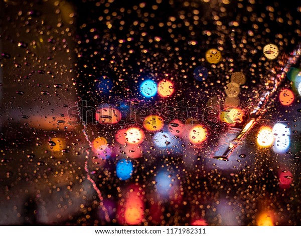 Rain\
drops on window with car light vintage color bokeh night light\
traffic jam ,City life in night in rainy\
season