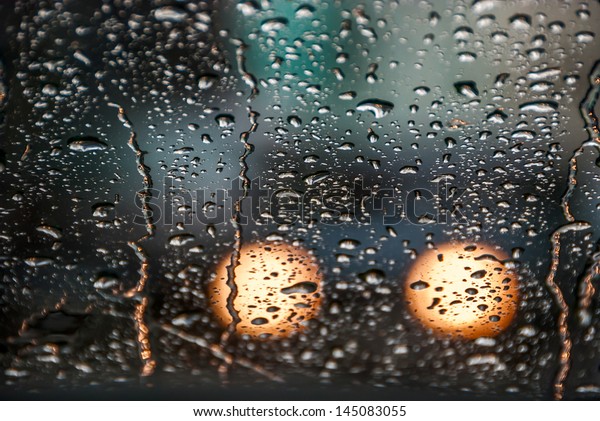 Rain drops\
on a window of car. Displays film\
grain.