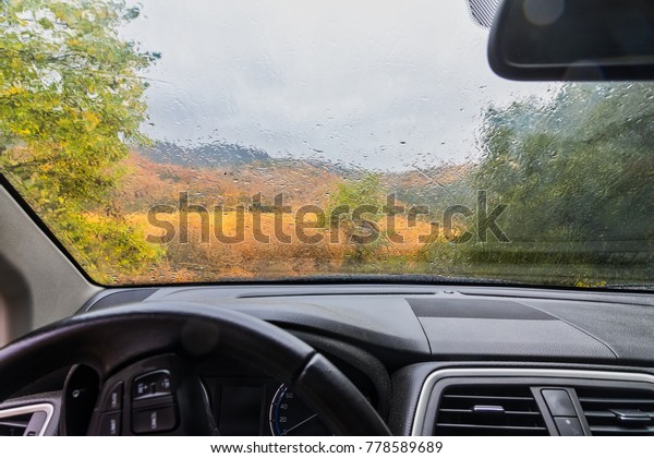 rain drops on the window of the car. autumnal\
rainy landscape blurred