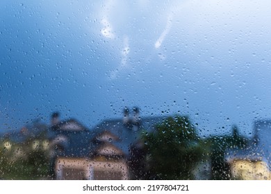 Rain Drops On Window Glass And Thunderstorm Lightning Blurred Background