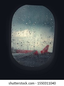 Rain Drops On The Window Of A Plane With Another Planes Tale In The Blured Background