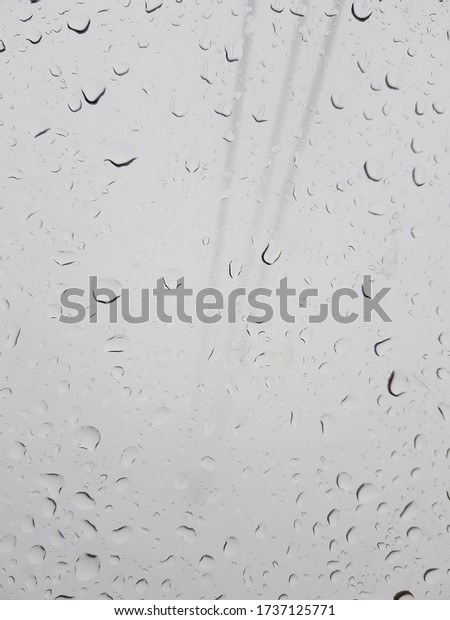 Rain drops on a window.\
Rainy foggy day. View from cable car cabin window. Wet glass\
background.