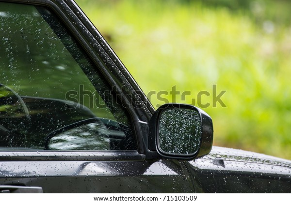 Rain drops on window and side\
mirror glass of the car, Abstract soft blurred and soft\
focus.