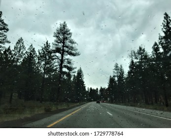 Rain Drops on Windshield on Back Road Through Scenic Forrest Landscape.