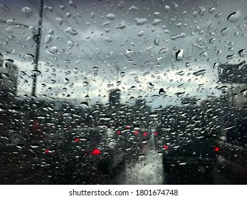 Rain drops on the windshield with the dark weather on the road, beautiful art of nature in the dark.
