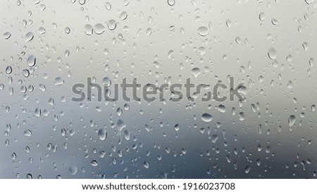Rain drops running down a window in a close up view