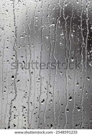 rain and drops running down window pain