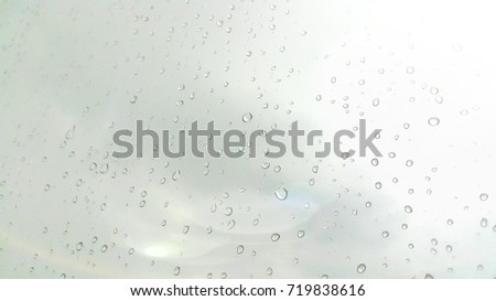Rain drops are sticking with the glass of office in the rainy day.