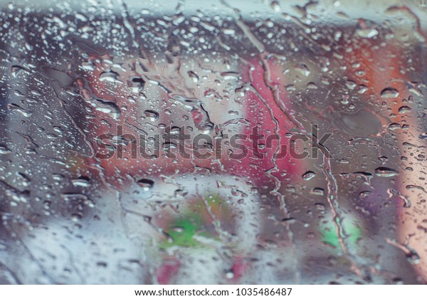 Rain drops water on car window\
background, view out of car now raining background, surface out of\
glass window car with rain drop water in the raining\
day