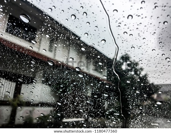 Rain drops water on car window\
background, view out of car now raining background, surface out of\
glass window car with rain drop water in the raining\
day