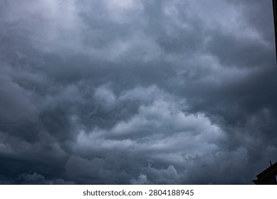 Rain Filled Thunderclouds Covering the Sky Before the Storm. Dark dramatic storm clouds gathering in the sky before heavy rainfall. Atmospheric cloudscape featuring dense cumulonimbus formations, overcast weather, and approaching thunderstorm. Perfect background for weather, climate, meteorology, nature, environmental concepts, forecasts, dramatic skies, and seasonal weather themes.