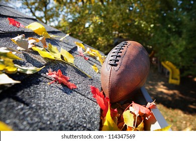 Rain Gutter Full Of Autumn Leaves With A Football