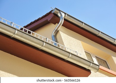 Rain Gutter, Rainwater Pipe And Snow Guard On A Tiled Roof