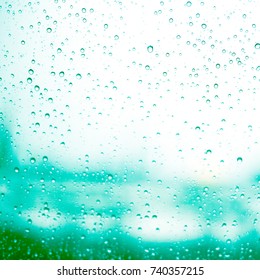 rain has a drop of water on the glass, the background is a blurred image of the city. - Shutterstock ID 740357215