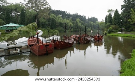 Rain in Lago Negro park tourist attraction in the city of Gramado with swan pedal boats and pirate ship