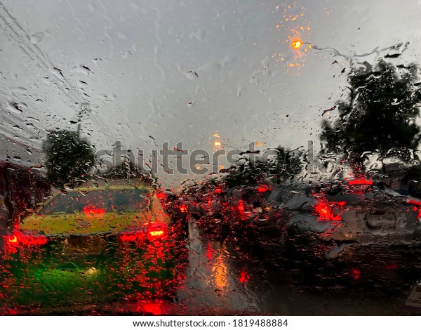 Rain on car window and traffic jams during rain. raining\
moment on road 