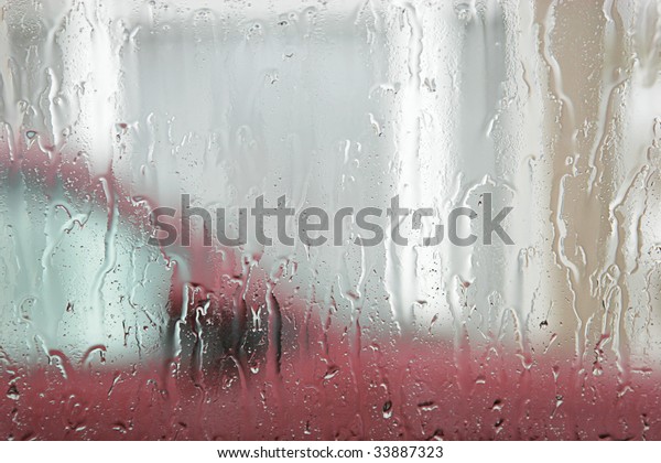 Rain on window,\
car and house in\
background.