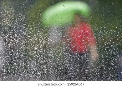 Rain on a window looking out to people in a street scene