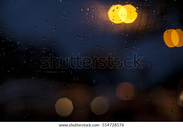 the rain outside the\
window. rain drops on glass, powerpoint background, night, blue and\
yellow. 