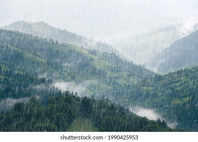 Rain over forest mountains. Misty mountain hills landscape on a rainy day.