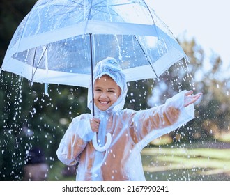 The Rain Provides Great Opportunities For Fun. Shot Of A Little Girl Playfully Standing In The Rain Holding Her Umbrella.