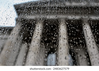 Rain reflection on a window outside a Parthenon