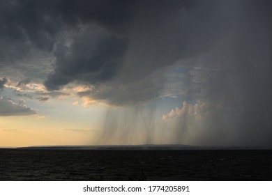 A Rain Squall Passes Over A River