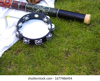 Rain stick and tambourine lying on the grass
