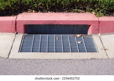 Rain Storm Water Drain Gutter On A City Street Red Curbside