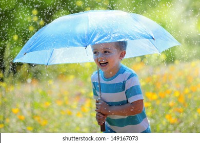 Rain and sunshine with a smiling boy holding an umbrella and running through a meadow of wildflowers