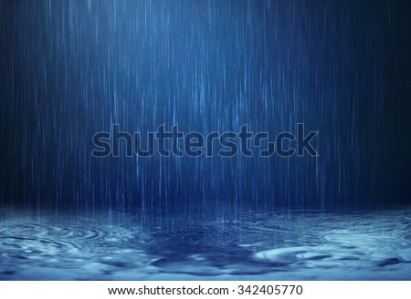 The rain water drop falling to the dark surface water on the floor in rainy season