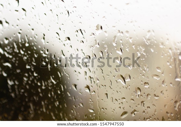 Rain water droplets with strong bokeh on car window at\
winter 