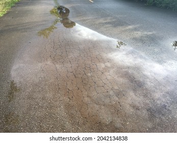 Rain Water In The Puddle In Cracked Asphalt Road