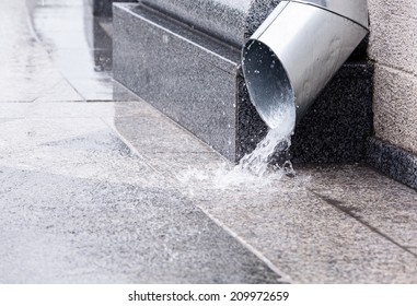 Rain Water Run Out Of A Downspout During A Thunderstorm