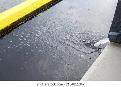 Rain Water Running From Downspout Drain Gutter In Parking Lot,selective Focus